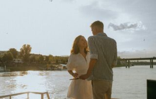 couples therapy - a couple enjoying each other's company on a dock overlooking a body of water.