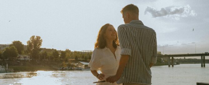 couples therapy - a couple enjoying each other's company on a dock overlooking a body of water.